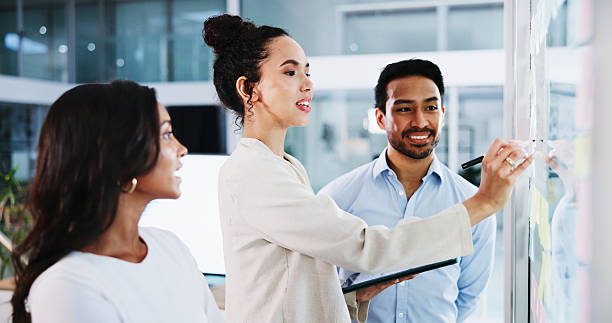 istock Glass wall, writing and business people in office, planning and tablet for project schedule. Employees, feedback and PR agency with idea, brainstorming or cooperation with company website or teamwork 2221659421