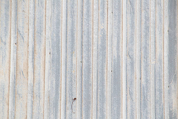 Grungy vertical lines on old corrugated metal building siding backdrop