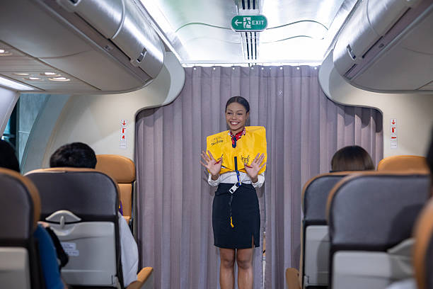 istock African flight attendant is demonstrating safety procedure using life jacket before taking off inside airplane for cabin crew and airline business 2221665020