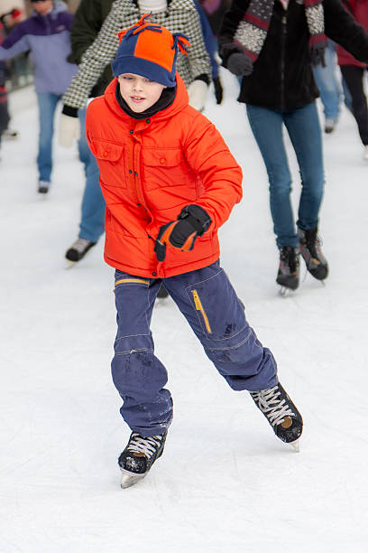 Front  view of boy ice skating outdoors in Millennium Park Chicago.