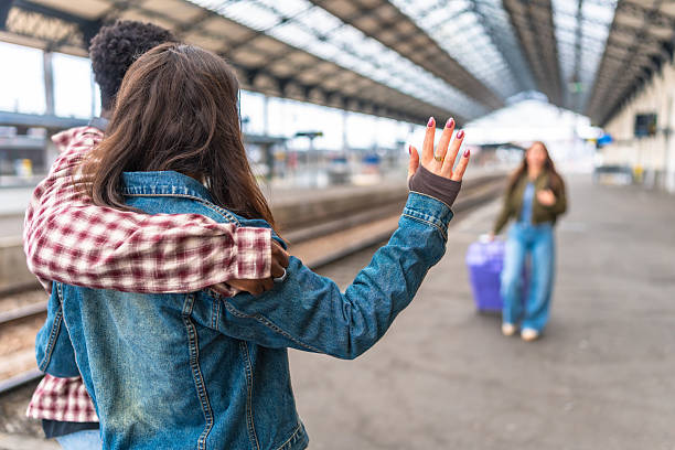 Friends waving goodbye at the train station after sharing a memorable journey together, capturing emotions of farewell and connection