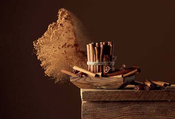 Cinnamon sticks on a old wooden table. Cinnamon powder explosion. Copy space.