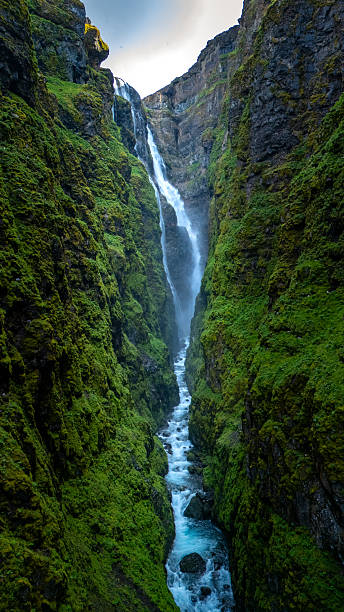 istock Breathtaking waterfall cascading through lush green cliffs in Icelandic canyon landscape 2221673047