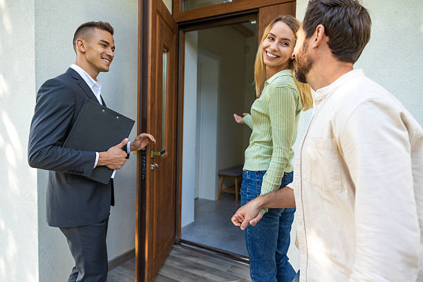 istock Agent inviting clients to tour new home in suburban setting 2221676553