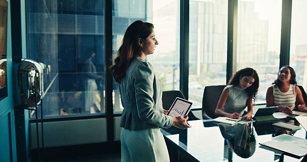 istock Boardroom, presentation and woman with tablet, group and data analyst with info, graphs and online. Meeting, colleagues and presenter with tech for insights, screen and people with digital report 2221679390