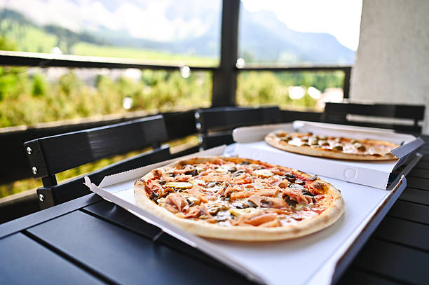 Delicious pizzas served on a balcony overlooking a mountain view