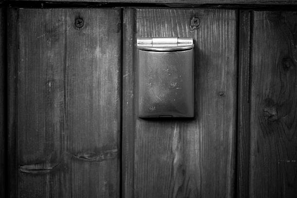Rustic mail slot set in an aged wooden door, capturing the charm of a vintage entryway in a quaint village stock photo