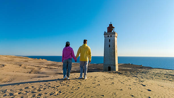 istock Couple holding hands with a lighthouse view in Denmark on a sunny day 2221683564