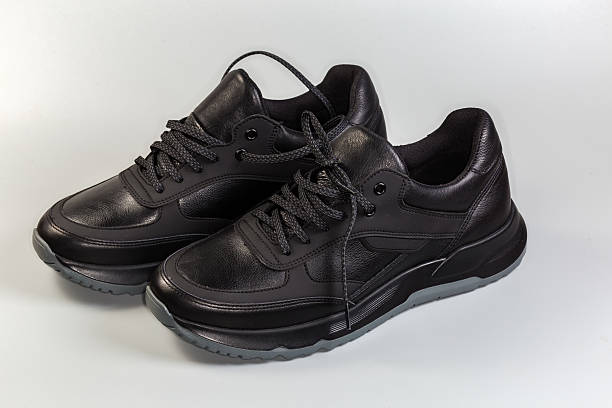 istock Black leather men's sneakers on a gray background 2221685286