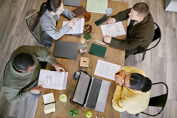 istock Diverse Young Adults Collaborating during Business Meeting Around Table 2221688038