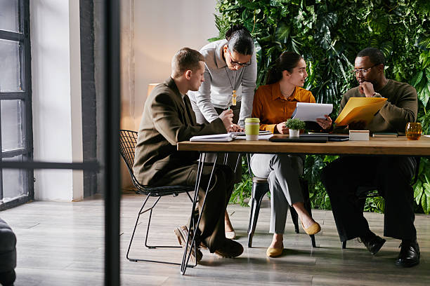istock Diverse Team Collaborating at Desk in Office with Green Plants 2221688259