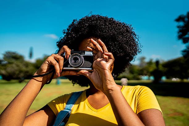 istock Young woman photographing using camera on public park 2221692911