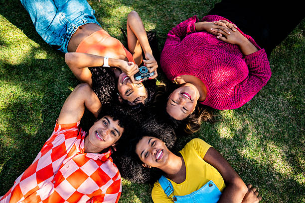 istock Friends photographing the sky while lying on grass 2221692937