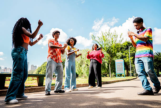 istock Young friends being filmed while dancing on public park 2221693084