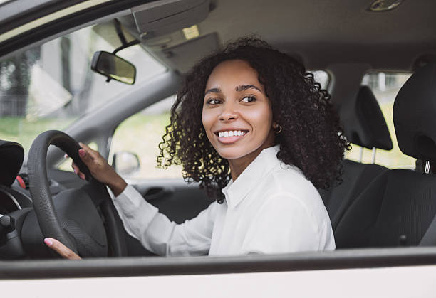 istock Smiling young woman driving a car 2221693954