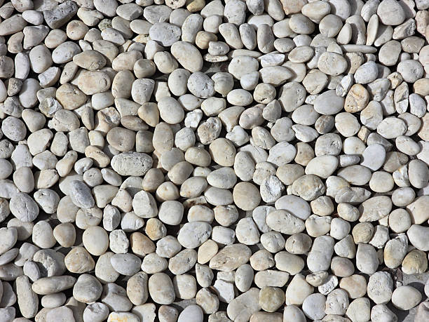 istock Smooth, rounded pebbles in various shades of gray and white create natural, textured surface, perfect for landscaping or decorative purposes 2221695370