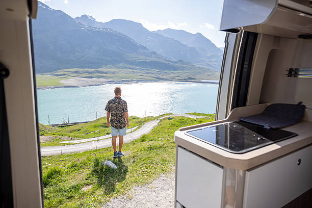 istock Man Enjoying Scenic Lake View from Camper Van 2221695406