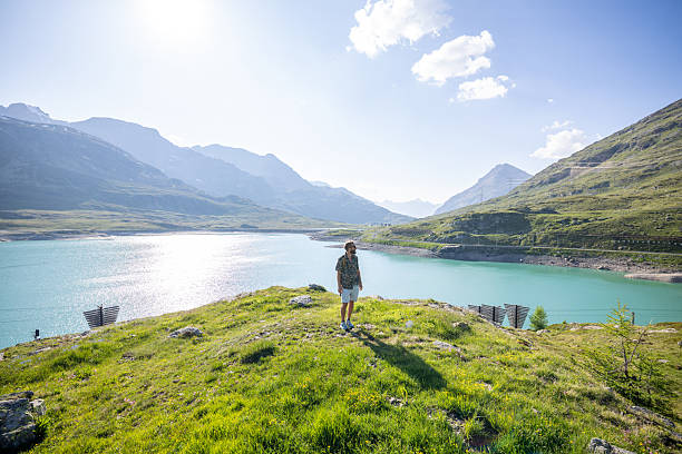 istock Young man exploring scenic mountain landscape by a lake 2221695527