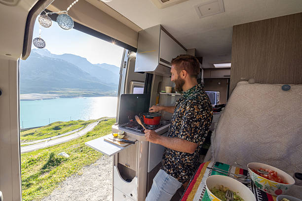 istock Man Cooking on a Camper Van Stove with Scenic Mountain View 2221695745