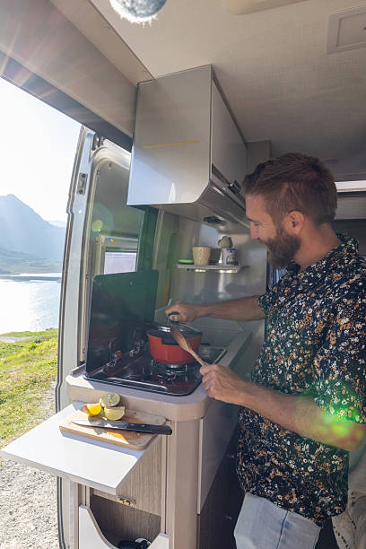 istock Man Cooking on a Camper Van Stove with Scenic Mountain View 2221695756