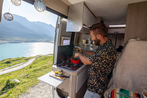 istock Man Cooking on a Camper Van Stove with Scenic Mountain View 2221695768