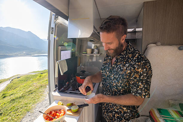 istock Man Preparing Meal in Camper Van with Scenic Mountain View 2221695819