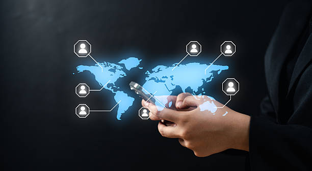 istock A person uses a smartphone with a digital world map and connected user icons, symbolizing global communication and networking. 2221695956