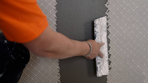 istock Construction worker applying cement with trowel on wall tiles 2221696201