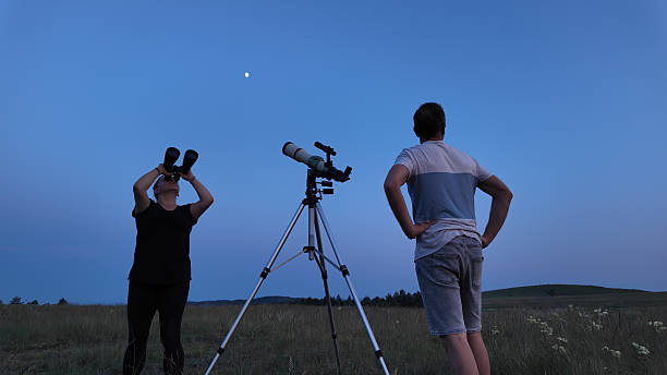 istock Amateur astronomers using telescope and binoculars for watching stars, Moon, planets and other celestial objects from a field in nature. 2221696637