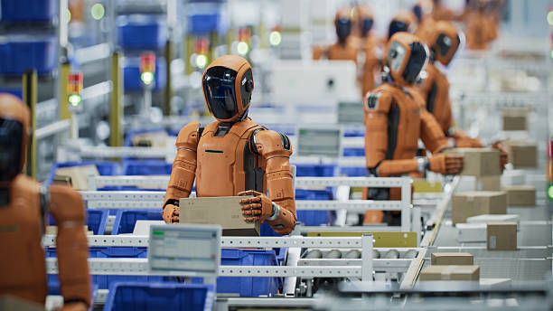 istock 3D Render: Autonomous AI-Enabled Humanoid Robots Work in Industrial Environment. They are Moving Boxes and Sorting Packages. Automated Warehouse or Logistics Center with General Purpose Humanoid Robots 2221698888