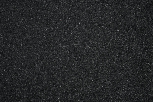istock Black sand background. Beautiful creative natural background with visible little sand texture. Sand on the ground. Rough texture, construction material background 2221701393