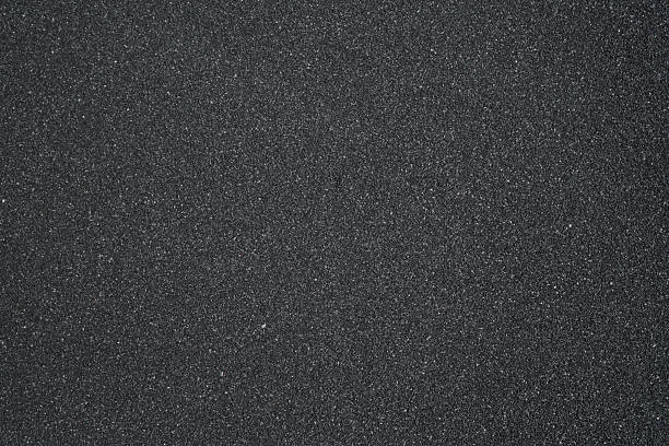 istock Black sand background. Beautiful creative natural background with visible little sand texture. Sand on the ground. Rough texture, construction material background 2221701425