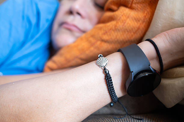 Pilgrim is taking a nap in a hostel with a scallop shell bracelet and a smartwatch, resting after a long day of walking on the camino de santiago