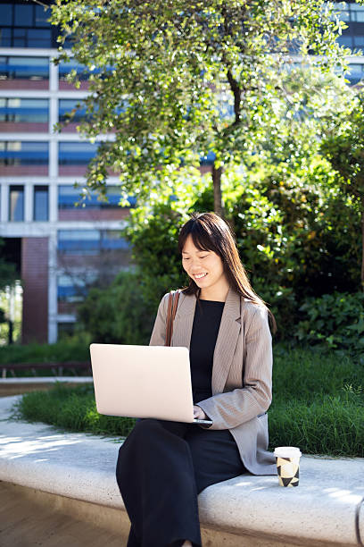 istock Businesswoman working on laptop outdoors in urban setting 2221703813
