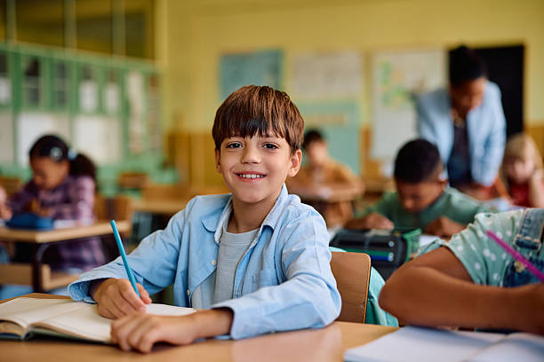happy schoolboy during a class at elementary school looking at camera. - skolbarn bildbanksfoton och bilder