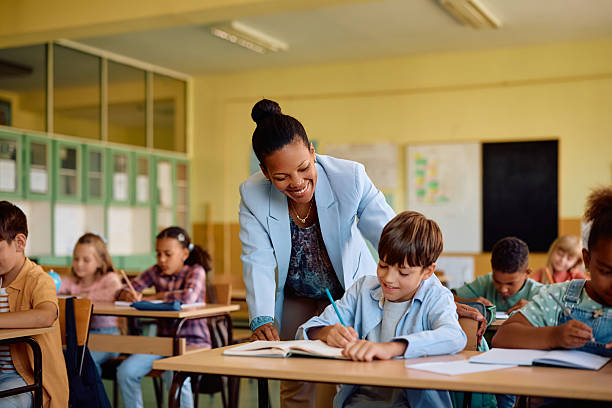 istock Happy black teacher assisting her student during a class at elementary school. 2221704329