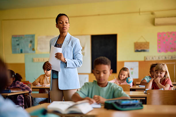 istock Black teacher and her students during a test in the classroom. 2221704368
