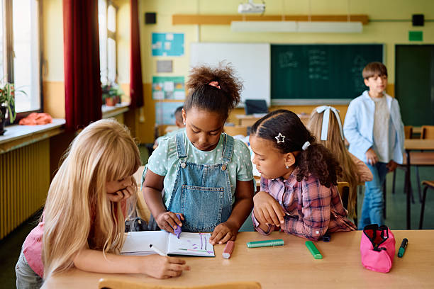 istock Group of girls learning together in the classroom at elementary school. 2221704522