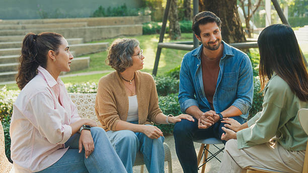 istock Diverse group people engaging in supportive group therapy session, sharing personal stories and advice to promote mental health and recovery in park. Mental health community concept. 2221707881