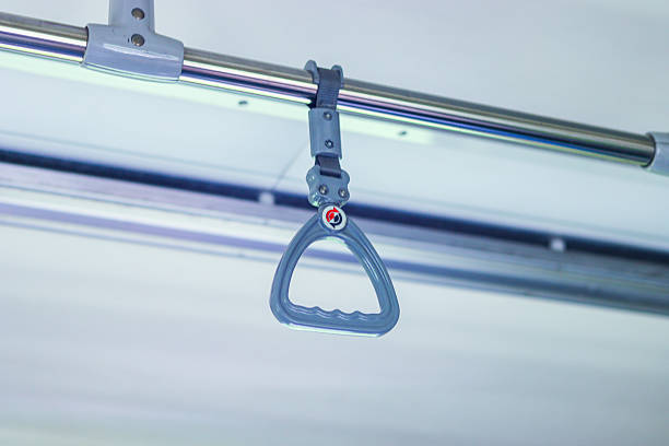 Blue plastic handle hanging from a metal bar, providing support for standing passengers in a bus or train