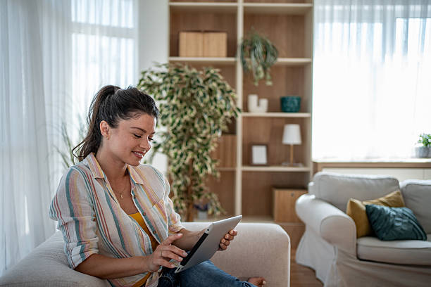 istock Young woman relaxing on sofa using digital tablet at home 2221711403