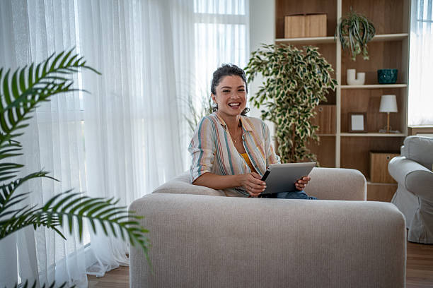 istock Young woman relaxing on sofa using digital tablet at home 2221711464