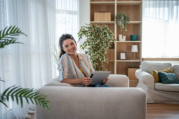 istock Young woman relaxing on sofa using digital tablet at home 2221711473