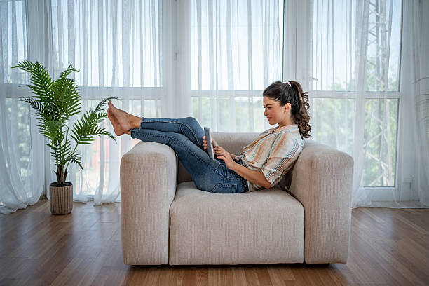 istock Young woman relaxing on sofa using digital tablet at home 2221711580