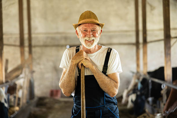 Smiling Farmer with a Hoe in a Barn