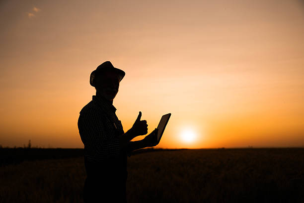 istock Silhouette Farmer Giving Thumbs Up at Sunset 2221712840