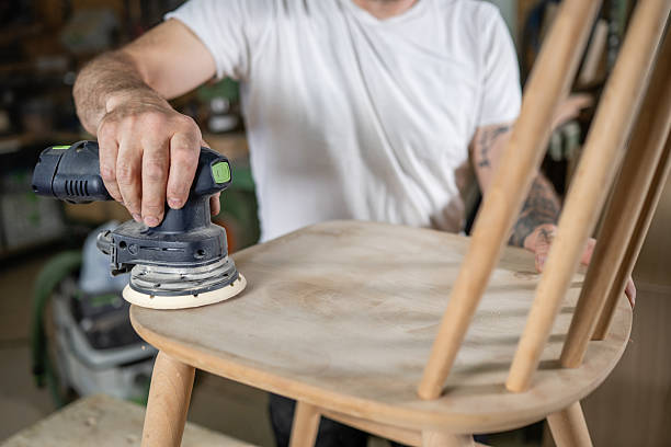 istock Carpenter sanding wooden chair in workshop with orbital sander 2221713572