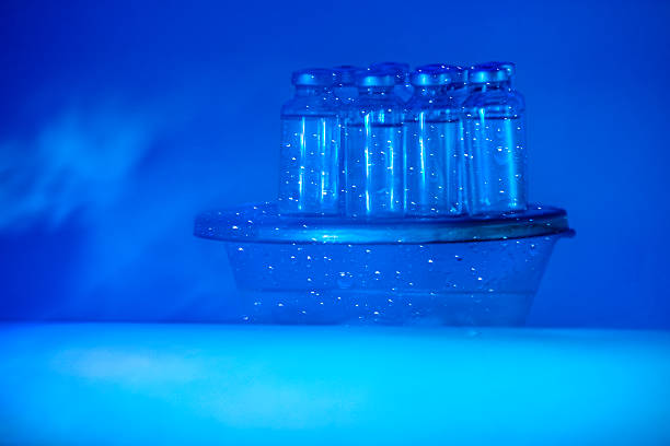 Sterile lab bottles with solution vaccine under ultraviolet light type C scientific concept to control Influenza H5N1, under 78 degrees