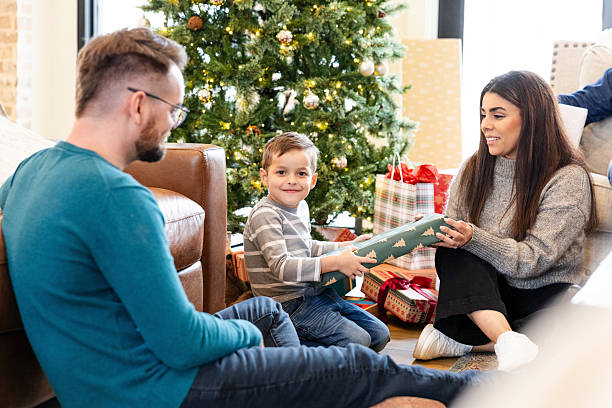 A young boy receives a gift from his parents during Christmas.