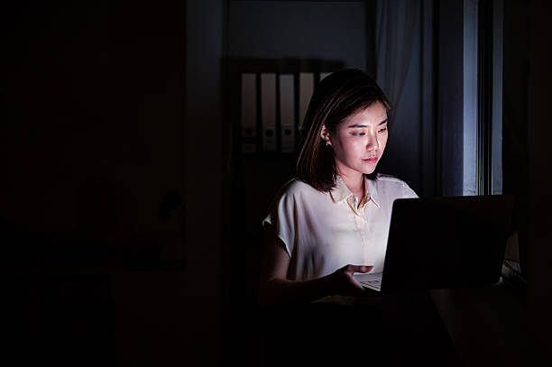 istock Young Asian woman tirelessly focused on her work late at night 2221720376